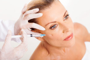 doctor giving mid age woman botox